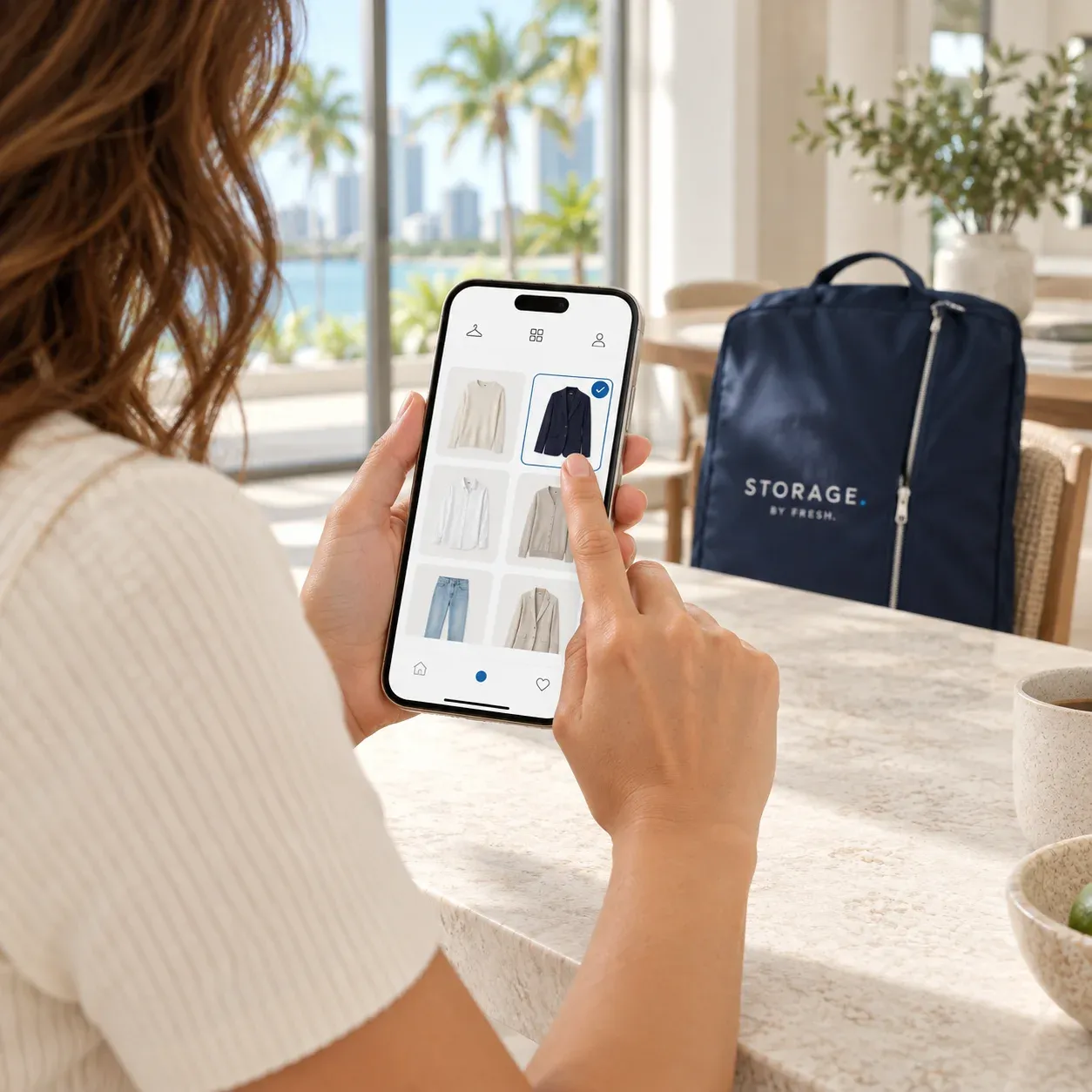 A woman selecting a navy blazer in the FRESH. digital closet on her phone
